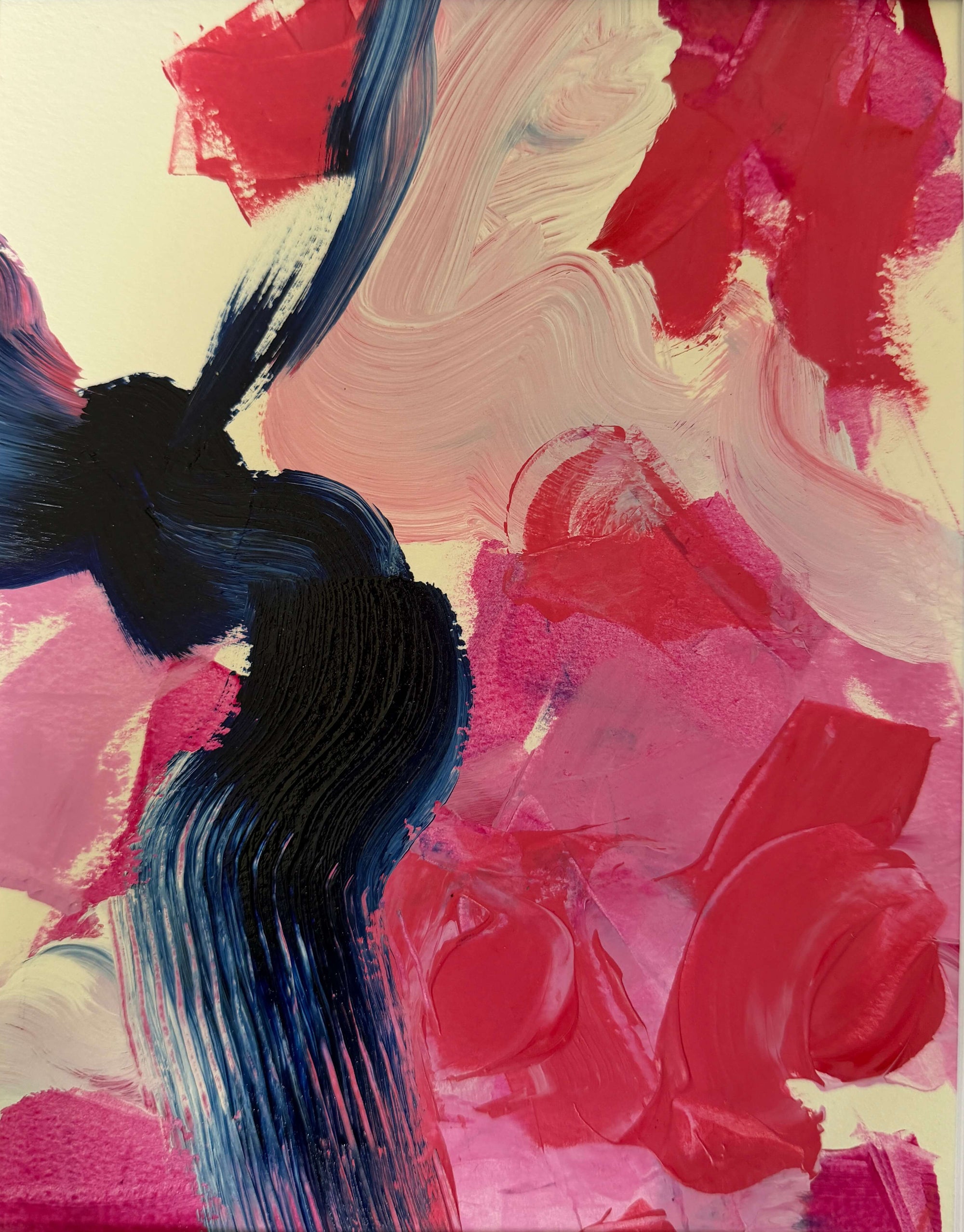 An abstract canvas painting featuring bold, textured brushstrokes in vibrant pink, deep red, cream, and dark navy blue, presented on a light beige wall.