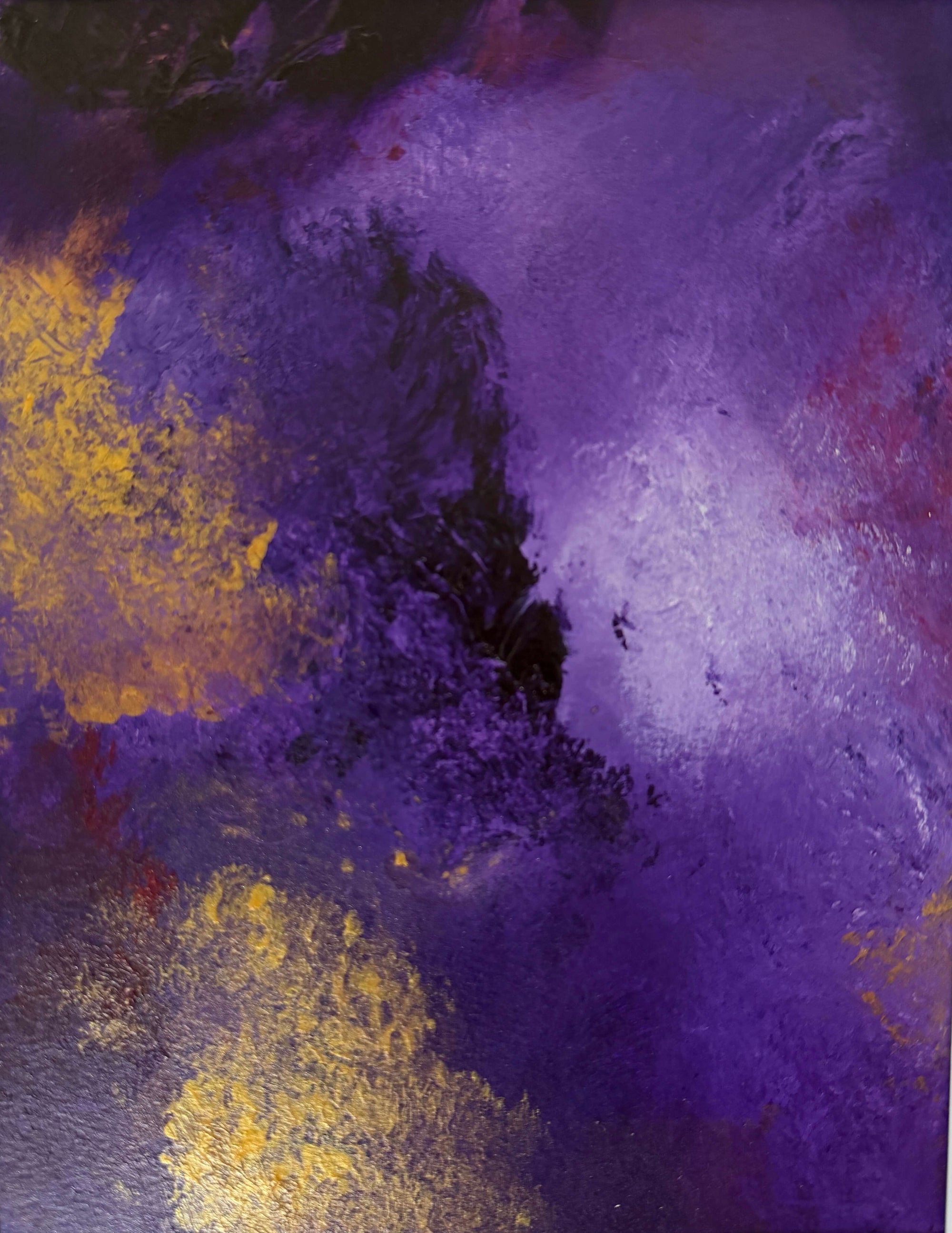 An abstract painting featuring a textured blend of deep purple, violet, and black with metallic gold leaf accents, displayed on a light off-white wall.